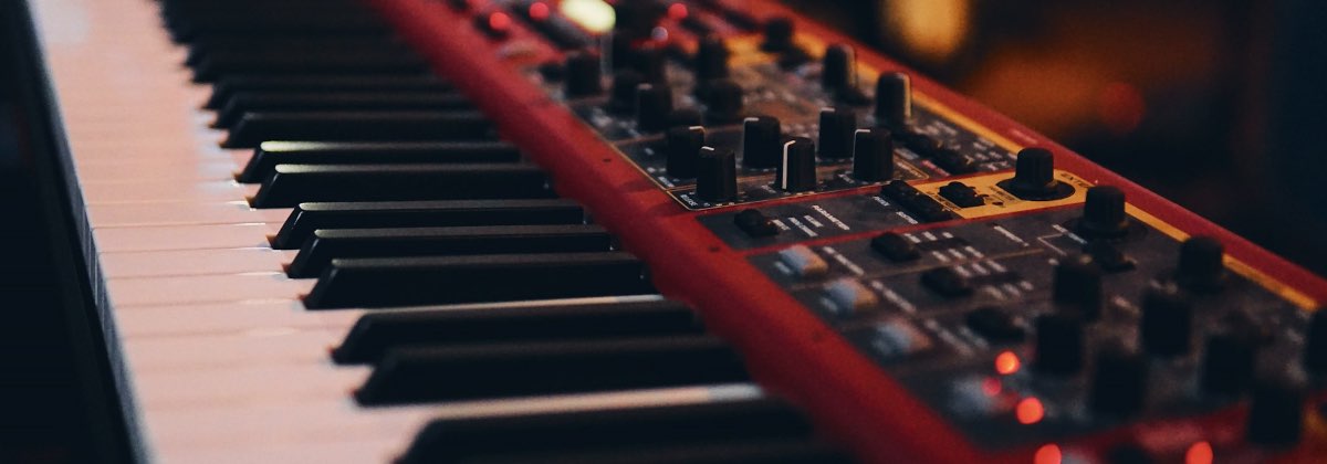 Hands playing a studio keyboard to find the key of a song