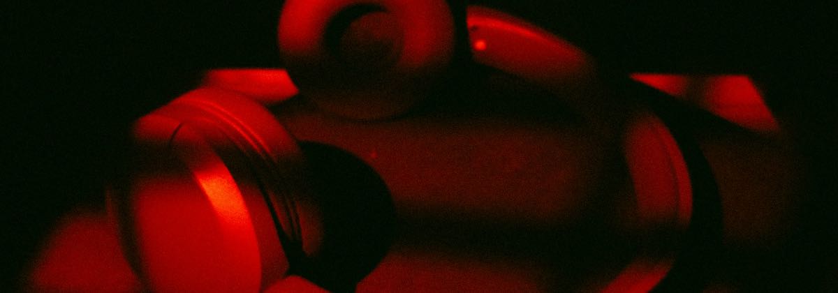 Red headphones on a dark surface used to check reverb settings on a slowed song edit