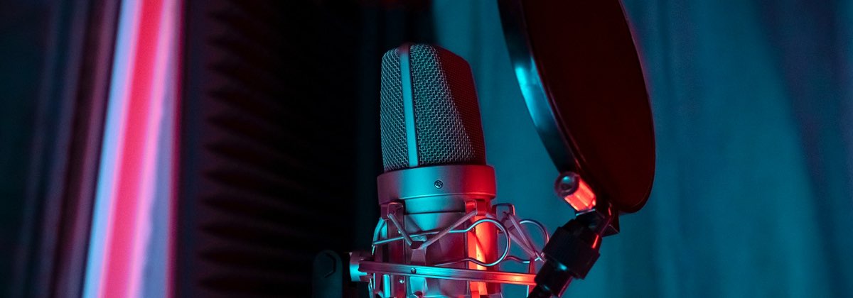 Singer in a recording booth in front of a microphone