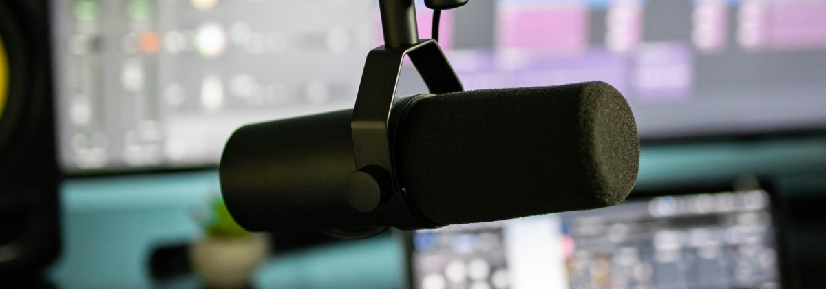 Studio microphone in front of a screen showing pitch analysis of a voice